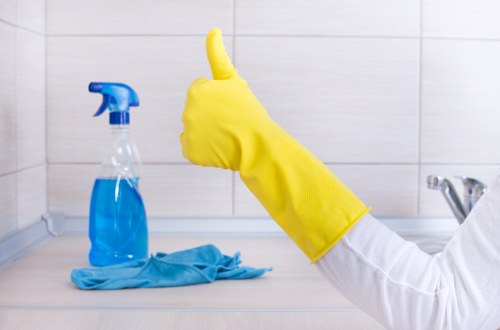 Local cleaner dusting and vacuuming in a Battersea home